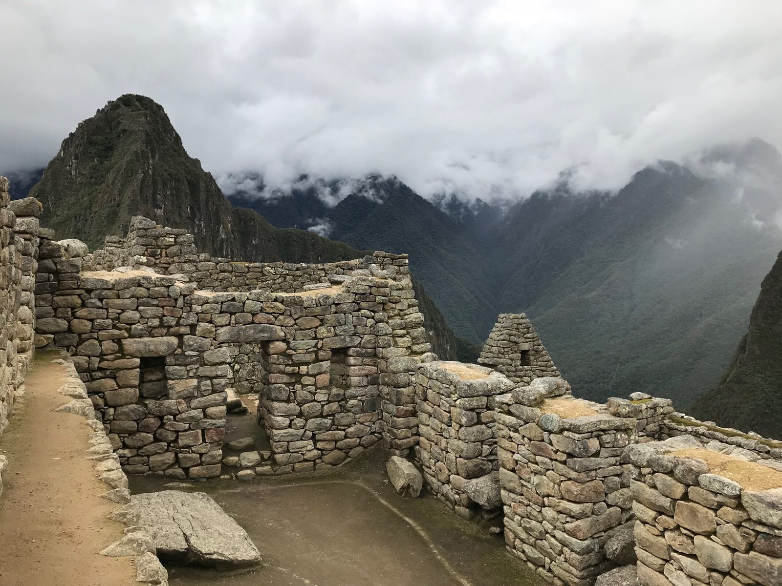 Stone structure at Machu Picchu with tightly fitted stones and trapezoidal door and window openings, built for earthquake resistance—an example of Inca engineering highlighted in Machu Picchu science travel.
