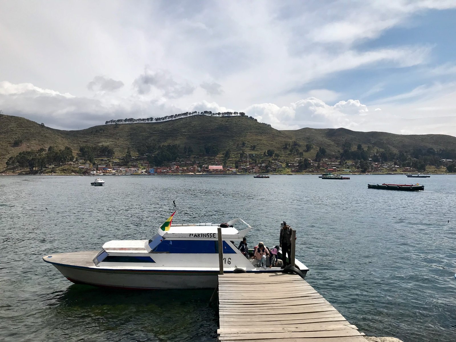 Small passenger boat docked at San Pablo de Tiquina on Lake Titicaca, Bolivia, used to ferry people across the Strait of Tiquina while buses cross on wooden barges.