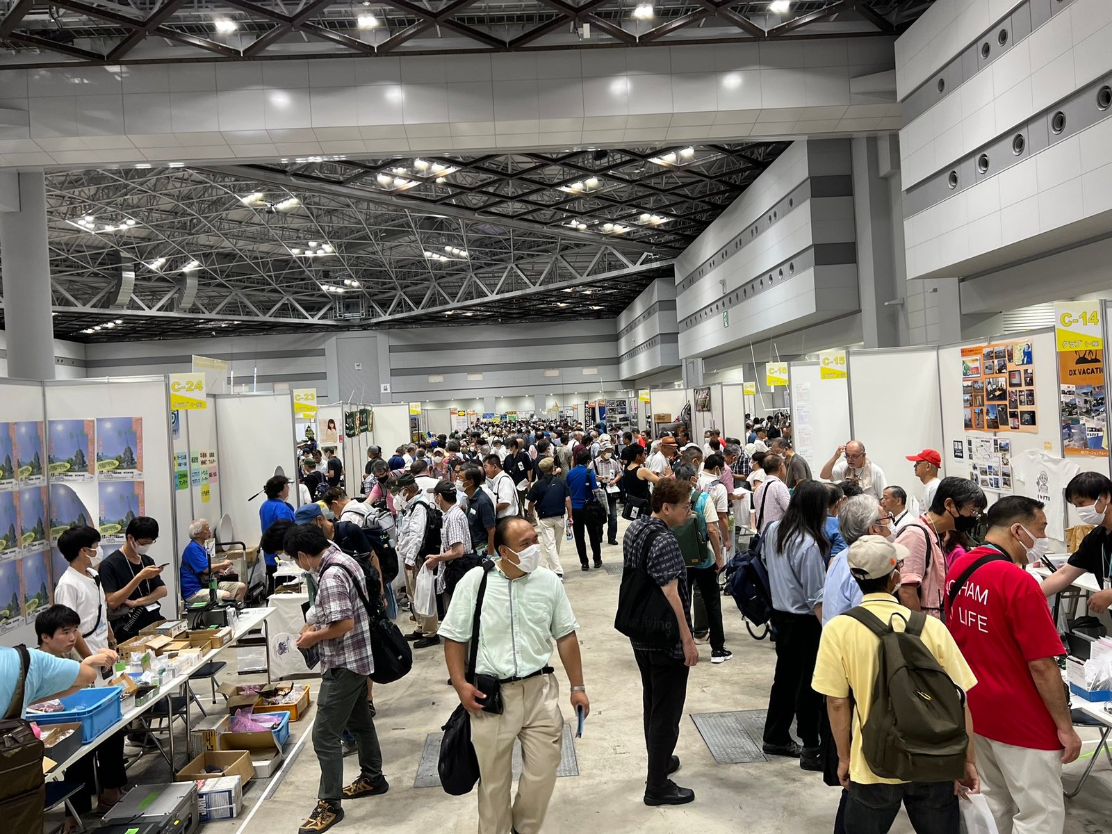 View of the JARL Ham Fair in Tokyo, showing vendors at booths and participants exploring the show floor. Photo by @PA5X_HAM.