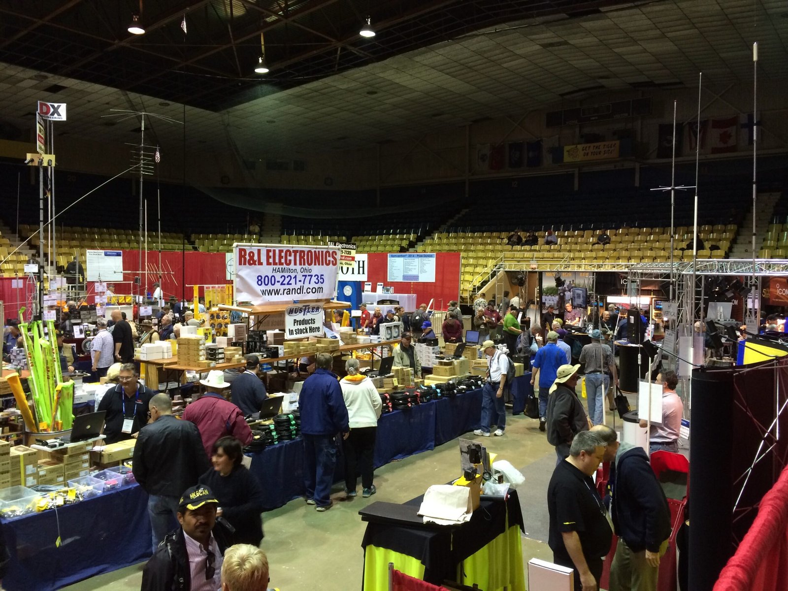 A vibrant scene of the main vendor display area at Dayton Hamvention, showing vendors selling ham radio products and participants browsing the goods.