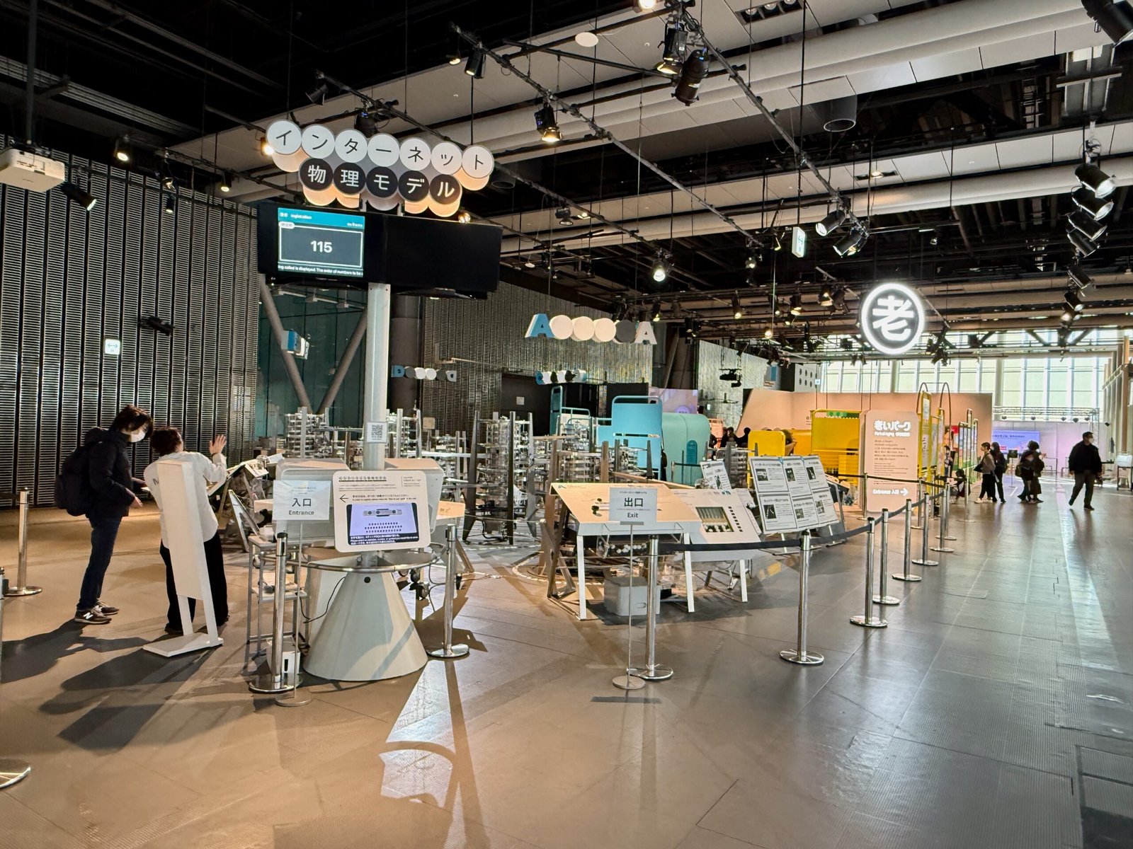 Visitors at Miraikan observe an interactive Internet exhibit displaying data flow and network models.