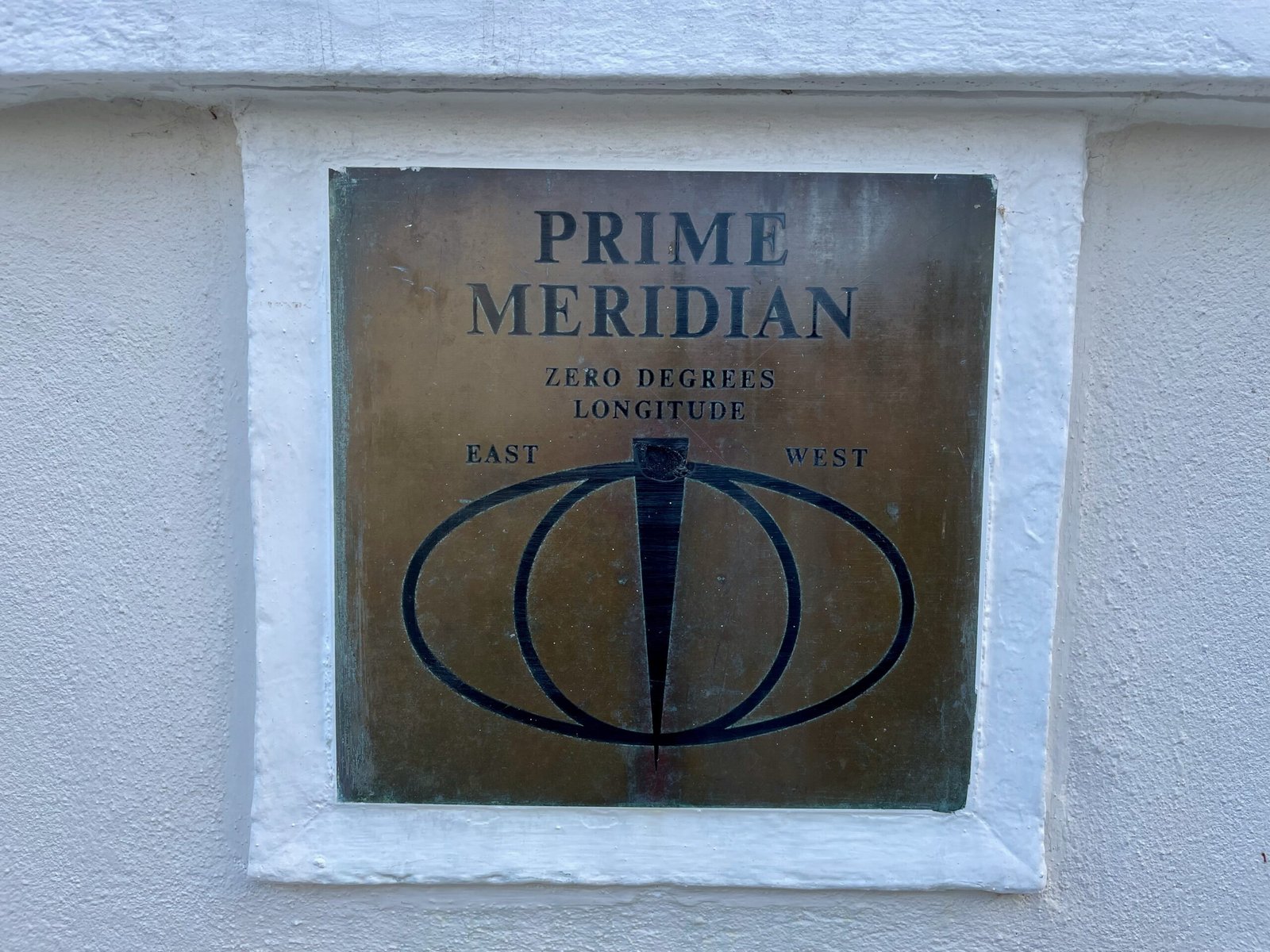 Prime Meridian marker on a wall in Greenwich, England—one of the symbolic places where time slows down.