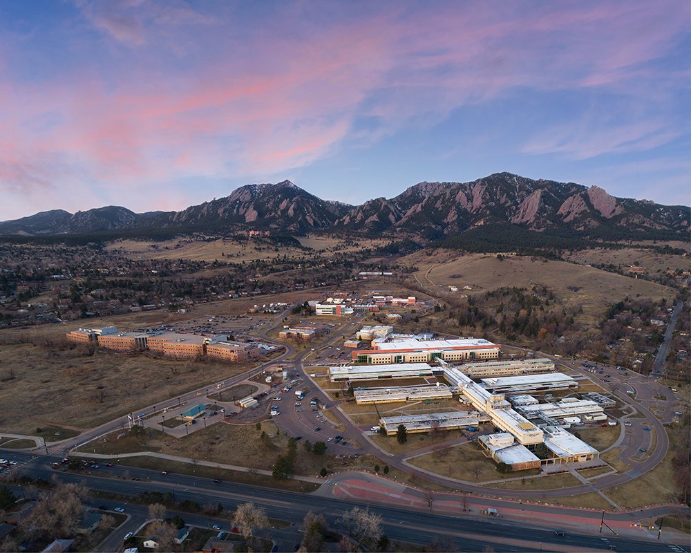 NIST campus in Boulder, Colorado, with mountain backdrop—one of the places where time slows down, measured down to billionths of a second.