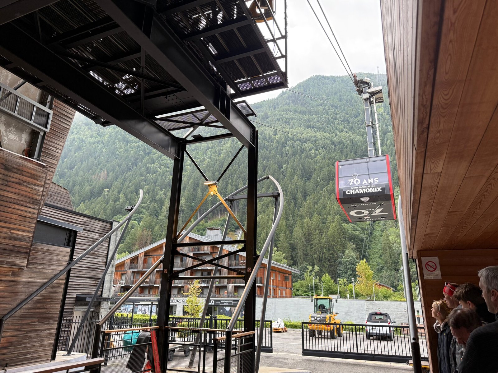 Aiguille du Midi cable car arriving at the Chamonix base station with visitors waiting to board for the ascent to the summit.