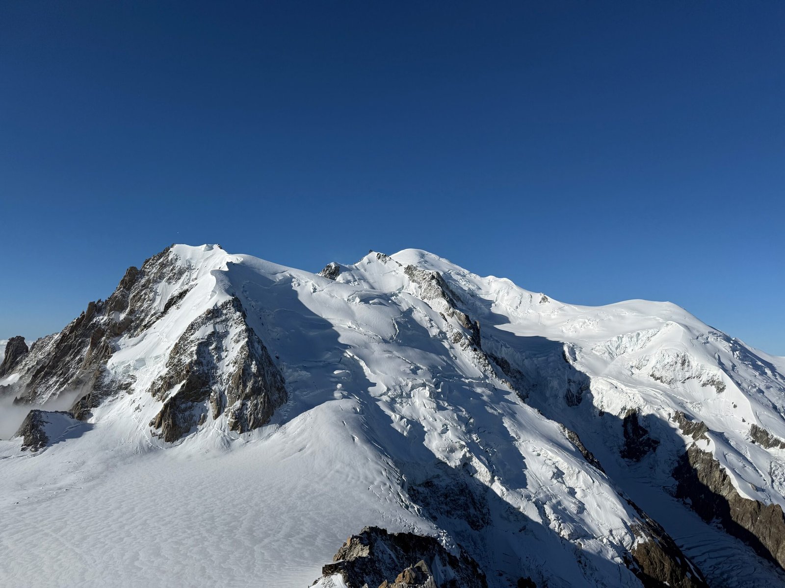 Snow-covered Mont Blanc, the rounded peak at the center of the photo, viewed from the south-facing observation platform at the Aiguille du Midi.