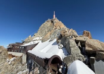 Aiguille du Midi summit station seen from the Mont Blanc side, with a snow-covered tubular passage leading toward the observation decks.
