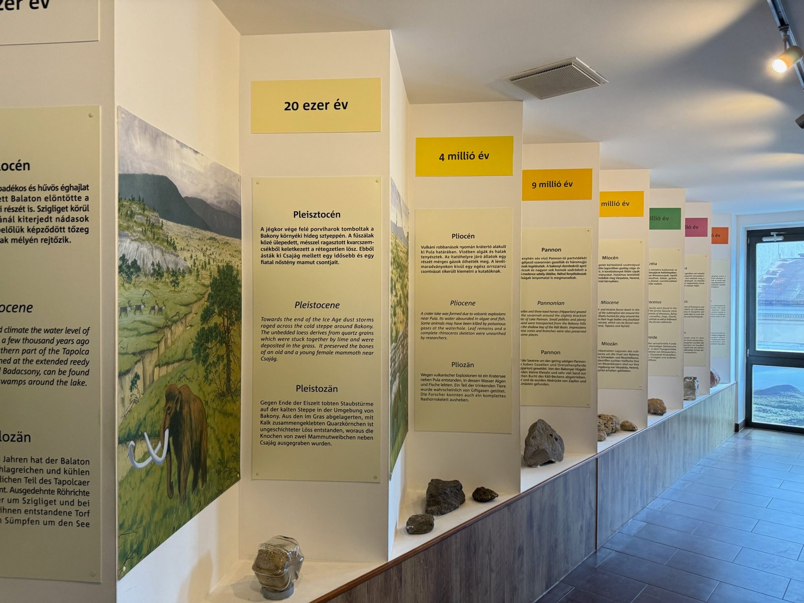 Exhibit panels in the Tapolca Lake Cave museum showing geology timelines with text in Hungarian, English, and German.