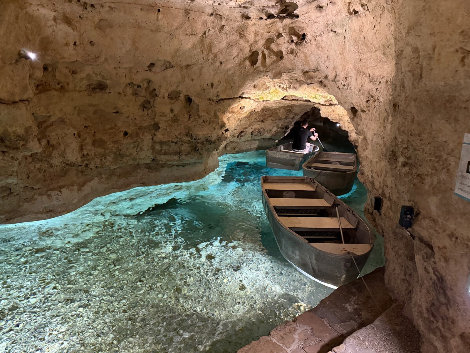 Boat landing at Tapolca Lake Cave with blue spring water and boats prepared for visitors to explore the underground river.