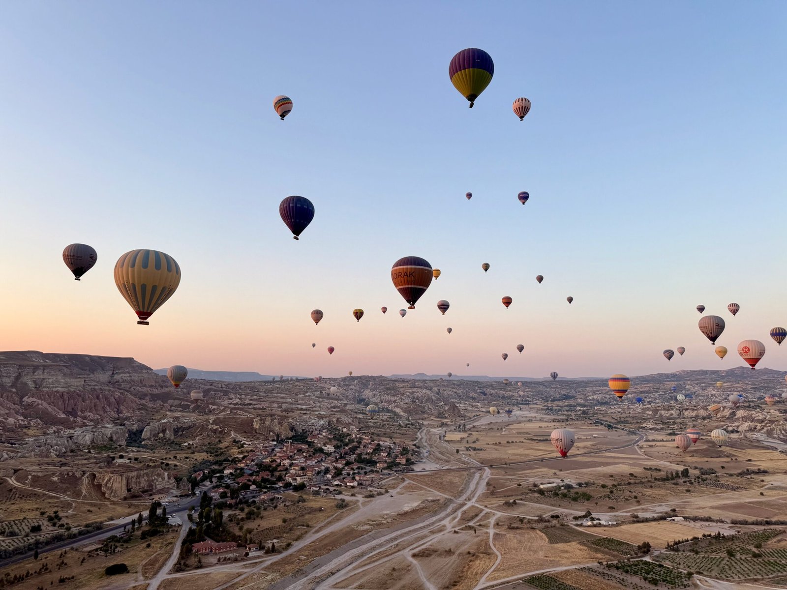 Hundreds of Cappadocia hot air balloons floating at sunrise over Türkiye’s rocky valleys and fairy chimney formations.
