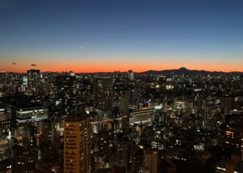 Tokyo Tower sunset view of the city skyline with Mount Fuji silhouetted on the horizon, seen from the main observation deck.