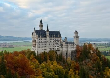 Neuschwanstein Castle seen from Marienbrücke in autumn, overlooking the Bavarian Alps, built from Jurassic limestone formed from an ancient coral reef.