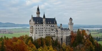 Neuschwanstein Castle seen from Marienbrücke in autumn, overlooking the Bavarian Alps, built from Jurassic limestone formed from an ancient coral reef.